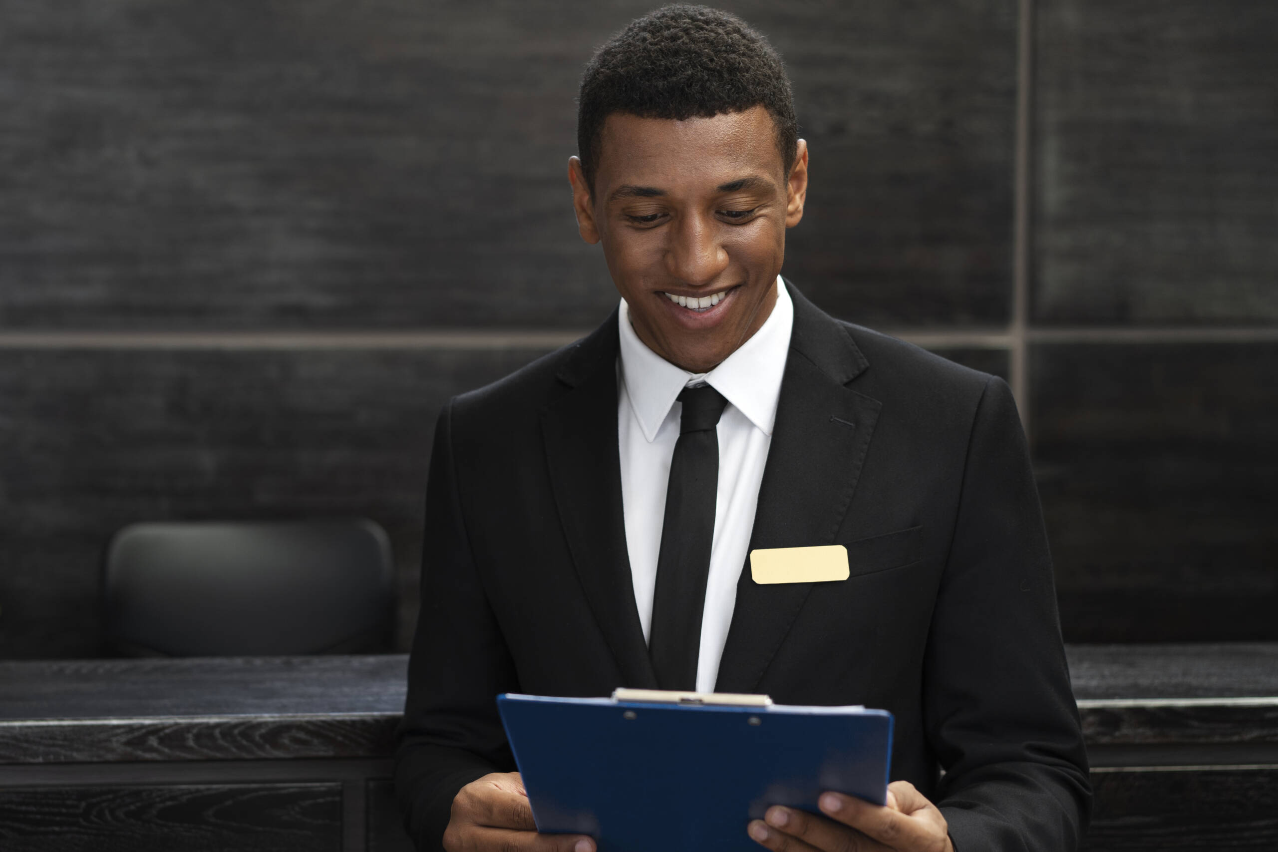 receptionniste-masculin-au-travail-costume-elegant receptionniste-masculin-au-travail-costume-elegant